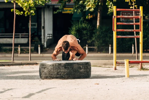 Man push a big tire. Street workout — Stock Photo, Image