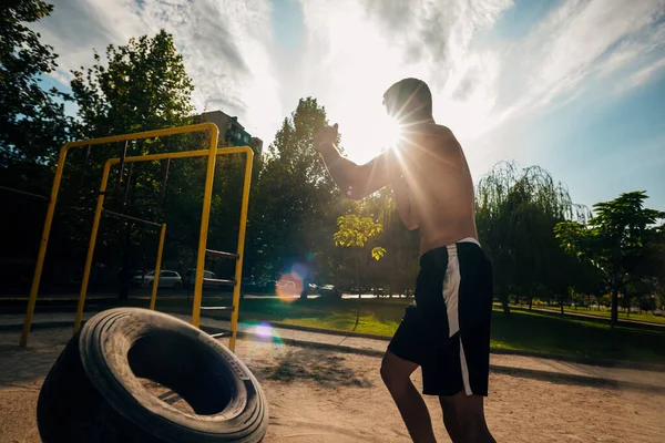 Shirtless man vända tunga däck på crossfit utomhus gym — Stockfoto