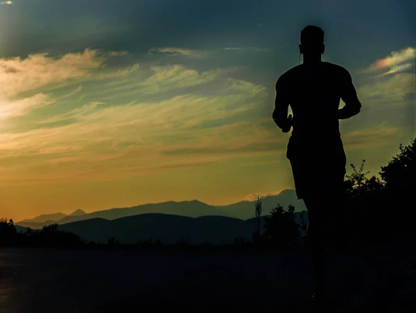 Чоловік-спортсмен бігун в інтенсивному спринті з навушниками під час виходу — стокове фото