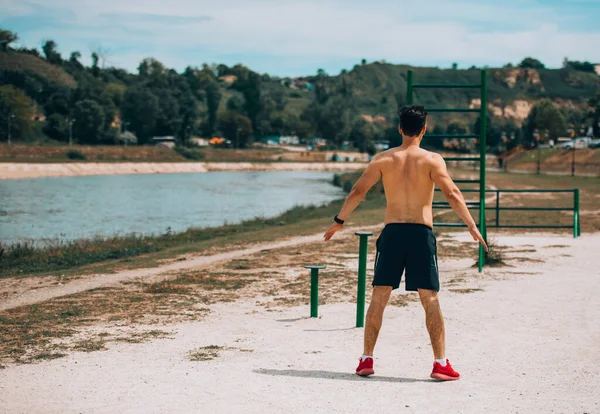 Junger, fitter Mann dehnt Körper im Freien — Stockfoto