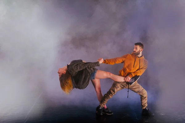 Couple dancing modern dance and showing off their leg stretch mo