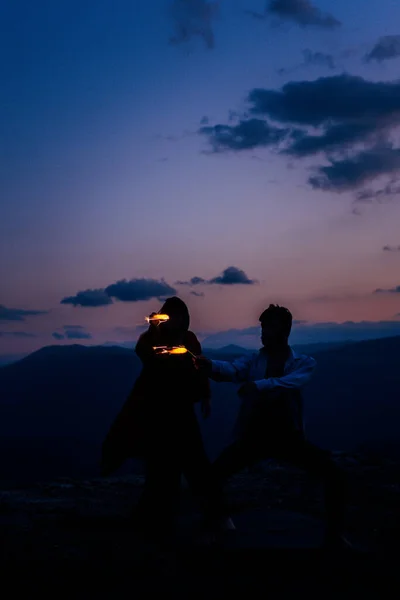 Retrato de um jovem amigos dançando na montanha contra o pôr do sol s — Fotografia de Stock