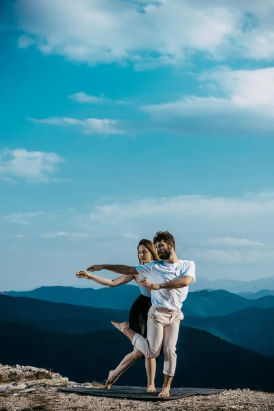 Una pareja de jóvenes bailando hip-hop en el acantilado de la montaña — Foto de Stock