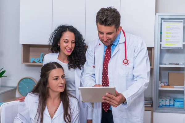 Zwei Krankenschwestern (Ärztinnen) und ein Arzt, der in einem — Stockfoto