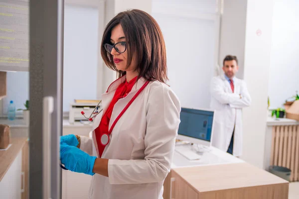 Mujer (mujer) Médico (enfermera) sosteniendo una jeringa mientras está de pie —  Fotos de Stock