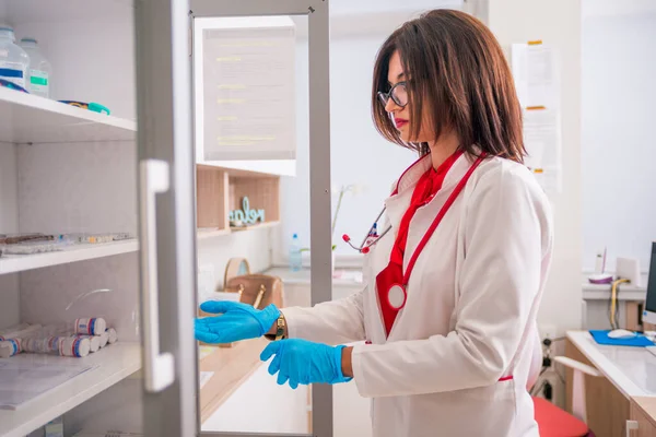 Mujer (mujer) Médico (enfermera) sosteniendo una jeringa mientras está de pie —  Fotos de Stock