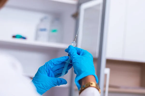 Nahaufnahme einer Ärztin (Krankenschwester), die eine Spritze hält, während sie — Stockfoto