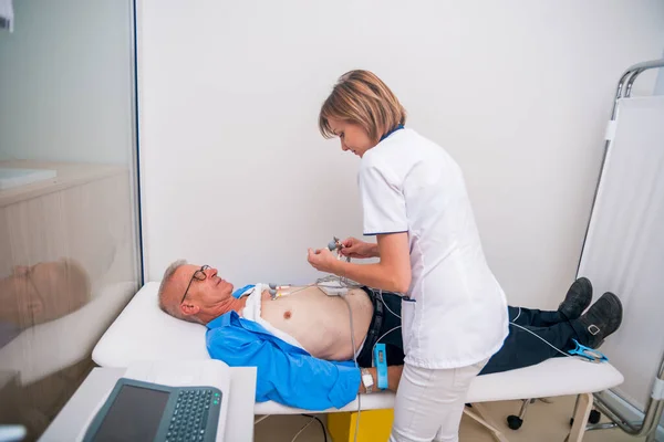 Enfermera (doctora) realiza prueba de EKG en un hombre mayor . —  Fotos de Stock