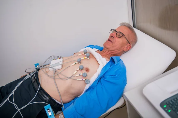 Enfermera (doctora) realiza prueba de EKG en un hombre mayor . —  Fotos de Stock