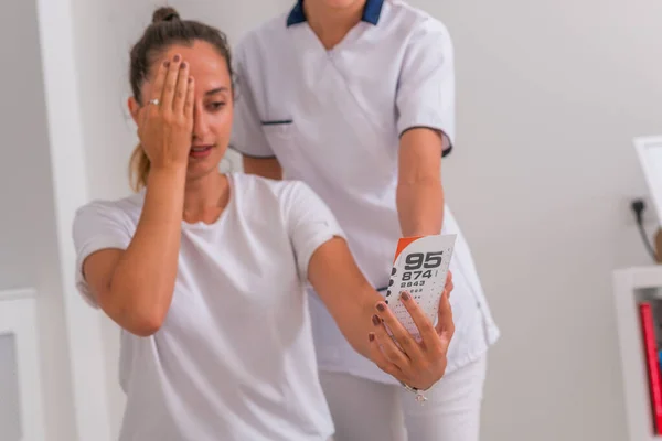 Mulher (menina) revisando a visão fechando os olhos com a mão. Ensaio ocular — Fotografia de Stock