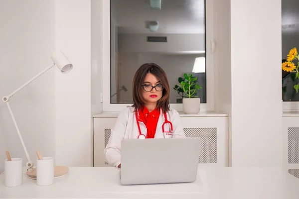 Retrato del médico especialista sentado en una silla en su escritorio whi —  Fotos de Stock