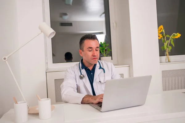 Porträt eines Arztes auf einem Stuhl an seinem Schreibtisch — Stockfoto