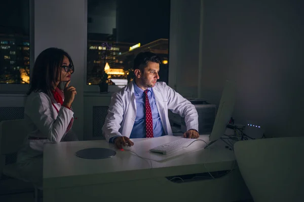 Los médicos trabajan en la oficina por la noche en una PC (computadora  ) —  Fotos de Stock