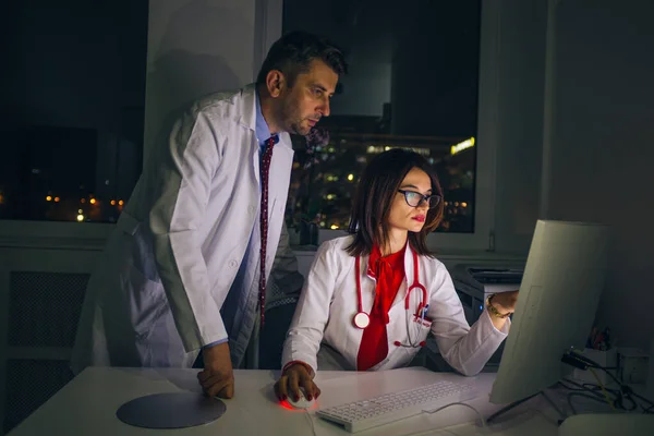 Los médicos trabajan en la oficina por la noche en una PC (computadora  ) — Foto de Stock