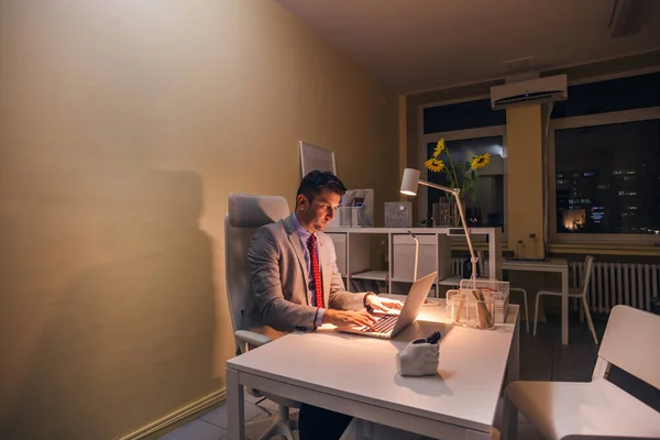 Ernsthafter Arzt arbeitet nachts an seinem Laptop (PC), Überstunden. — Stockfoto