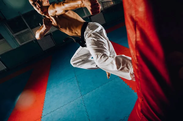 Entrenamiento de Kickboxer en el gimnasio pateando el saco de boxeo — Foto de Stock