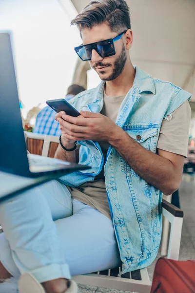 Homem atraente no lounge do aeroporto usando smartphone — Fotografia de Stock