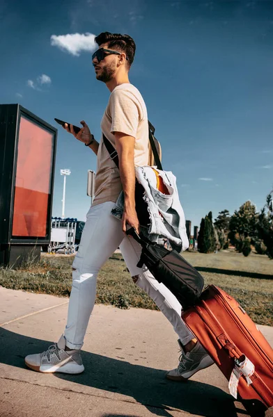 Homem usando celular enquanto espera táxi do aeroporto — Fotografia de Stock