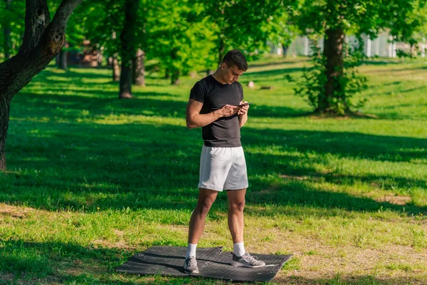 Sportowiec Sprawdzający Swój Telefon Podczas Przerwy Treningu Parku — Zdjęcie stockowe
