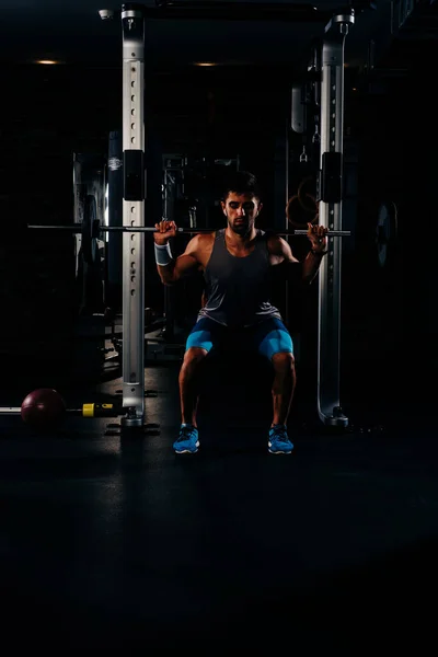 Λεπτός Μυώδης Άνδρας Άρση Βαρών Στο Γυμναστήριο Υψηλή Αντίθεση Σκοτεινή — Φωτογραφία Αρχείου