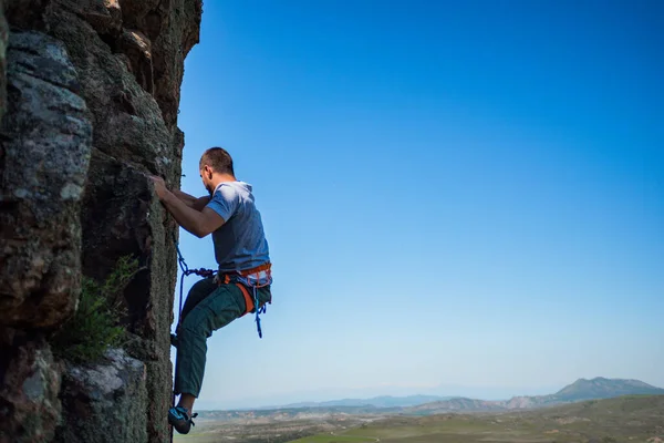 若いです男性岩クライマー上の挑戦的なルート上の垂直崖 — ストック写真