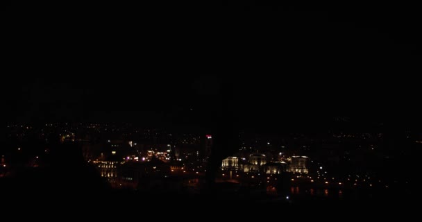 街の明かりの前の丘の上で夜に踊る男性ダンサーのシルエット 低キーの映像 — ストック動画