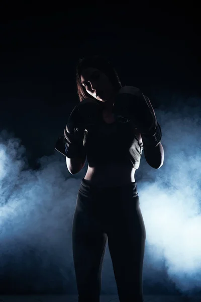 一个戴着拳击手套的女模特背景下的白烟人物肖像 — 图库照片