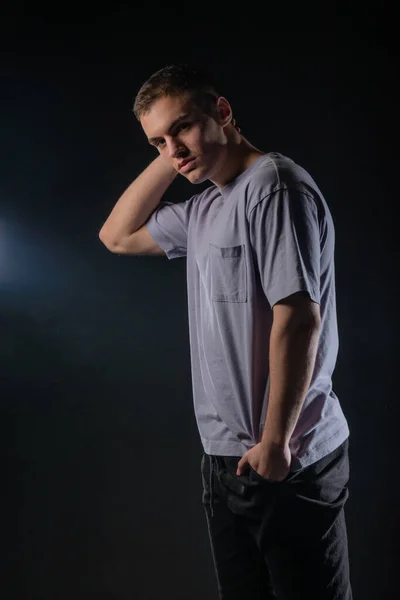 Retrato Joven Guapo Con Una Camiseta Gris Pantalones Negros Posa —  Fotos de Stock