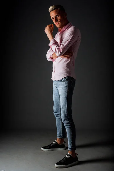 Atraente Jovem Elegante Homem Posando Moda Jeans Azul Camisa Rosa — Fotografia de Stock