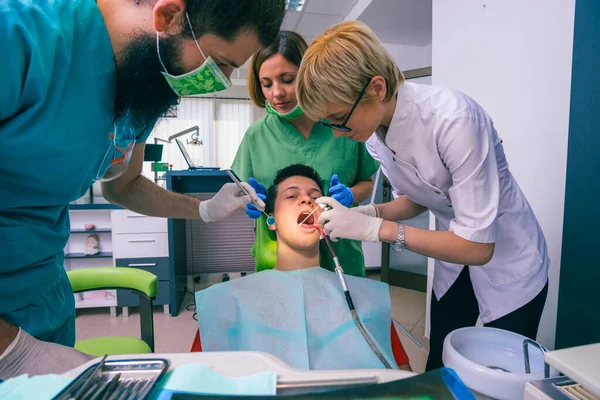 Команда Стоматологів Лікує Зуби Пацієнта Молодого Хлопчика Використовуючи Зубні Інструменти — стокове фото