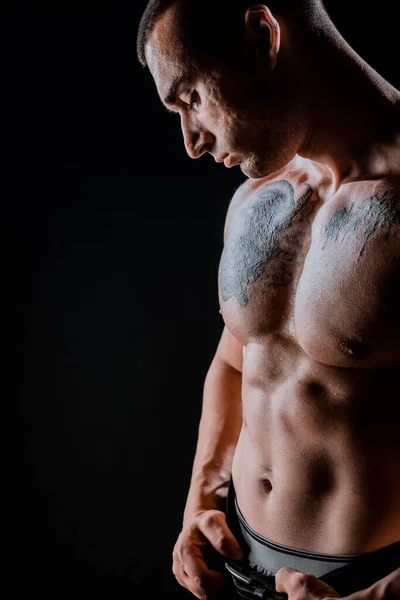 年轻肌肉男的画像是在黑暗的背景下弯曲肌肉 — 图库照片