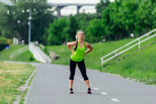 健康的年轻的女运动员 晨跑前伸展着身体 — 图库照片