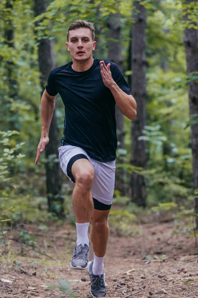 一个英俊的慢跑者在森林里慢跑的特写 — 图库照片
