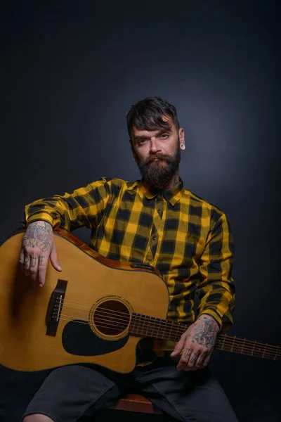 Człowiek Tatuażami Brodą Hoduje Gitarę Nosi Tartan Żółty Czarny Koszula — Zdjęcie stockowe