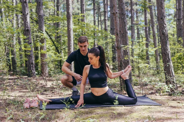 Joven Pareja Activa Haciendo Ejercicios Estiramiento Bosque Una Esterilla Yoga — Foto de Stock