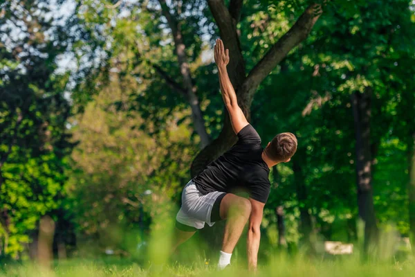 Attractive Caucasian Young Man Stretching Doing Yoga Exercises Green Grass — Stock Photo, Image