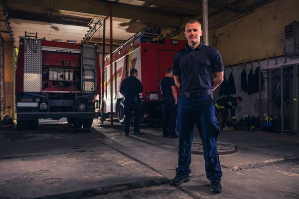 Retrato Del Guapo Bombero Pie Contra Camiones Estación Bomberos —  Fotos de Stock