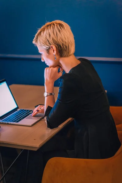 Kafeteryada Otururken Dizüstü Bilgisayarıyla Çalışan Sarışın Bir Kadınının Yan Görüntüsü — Stok fotoğraf