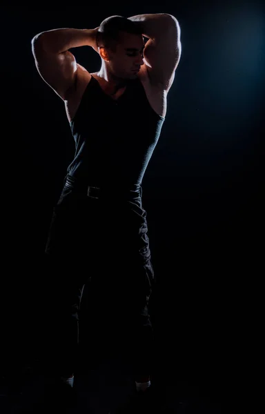 ボディービルポーズ 美しいスポーティ男の男性の力 フィットネス筋肉男でシャツに暗い背景 — ストック写真