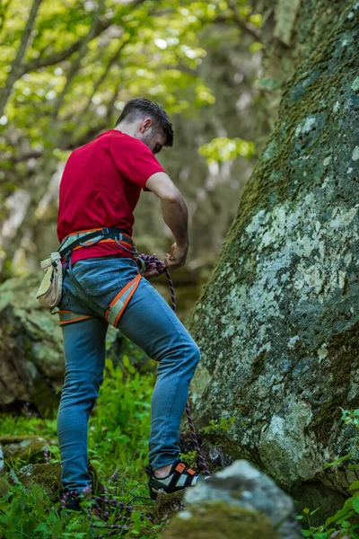 年轻的男性攀岩者在陡峭的悬崖上攀登具有挑战性的路线 — 图库照片
