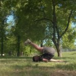 Young man trying to make a handstand in the park in the morning