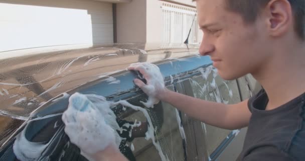 Nastolatek Myje Samochód Gąbką Pianką — Wideo stockowe