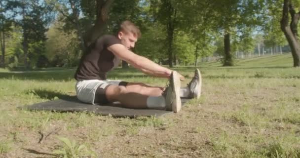 Junger Mann Dehnt Sich Morgens Park Einem Sonnigen Tag Vor — Stockvideo