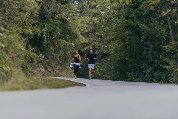 一对运动型的夫妇在一条街上跑着 彼此相邻 健康和健康的概念 — 图库照片