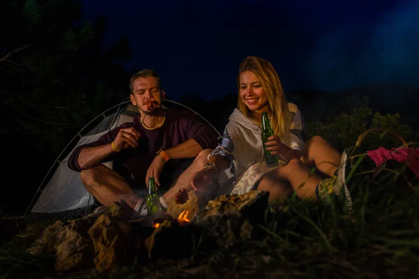 在夜间的森林篝火旁 您可以在一起烘焙和吃香肠 喝啤酒 放松身心 浪漫篝火概念 — 图库照片