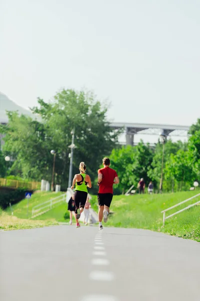 公園を走る若いスポーツカップルの後ろからの眺め — ストック写真