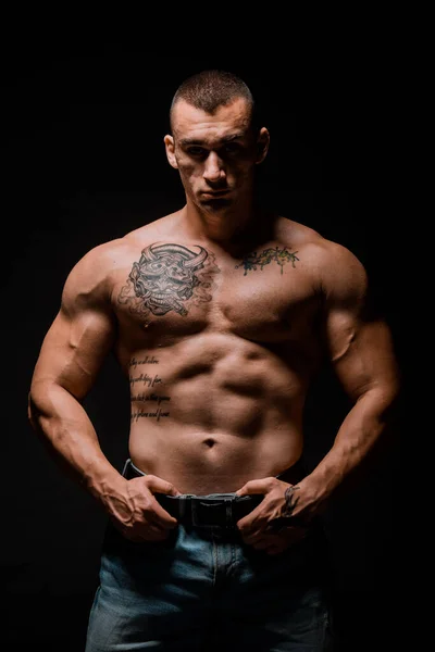 근육질의 남자가 어두운 배경에서 근육을 구부리고 — 스톡 사진