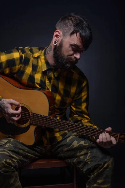 Mężczyzna Tatuażami Brodą Żółtej Tartanowej Czarnej Koszuli Gra Gitarze Studio — Zdjęcie stockowe