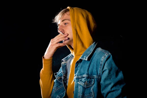 Sigara Sarı Kapüşonlu Poz Veren Çekici Genç Bir Erkek Model — Stok fotoğraf