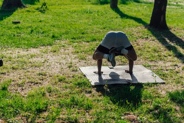 公園でカラスのポーズやBakasana ヨガAsana 屋外で練習スポーティ若い男 — ストック写真